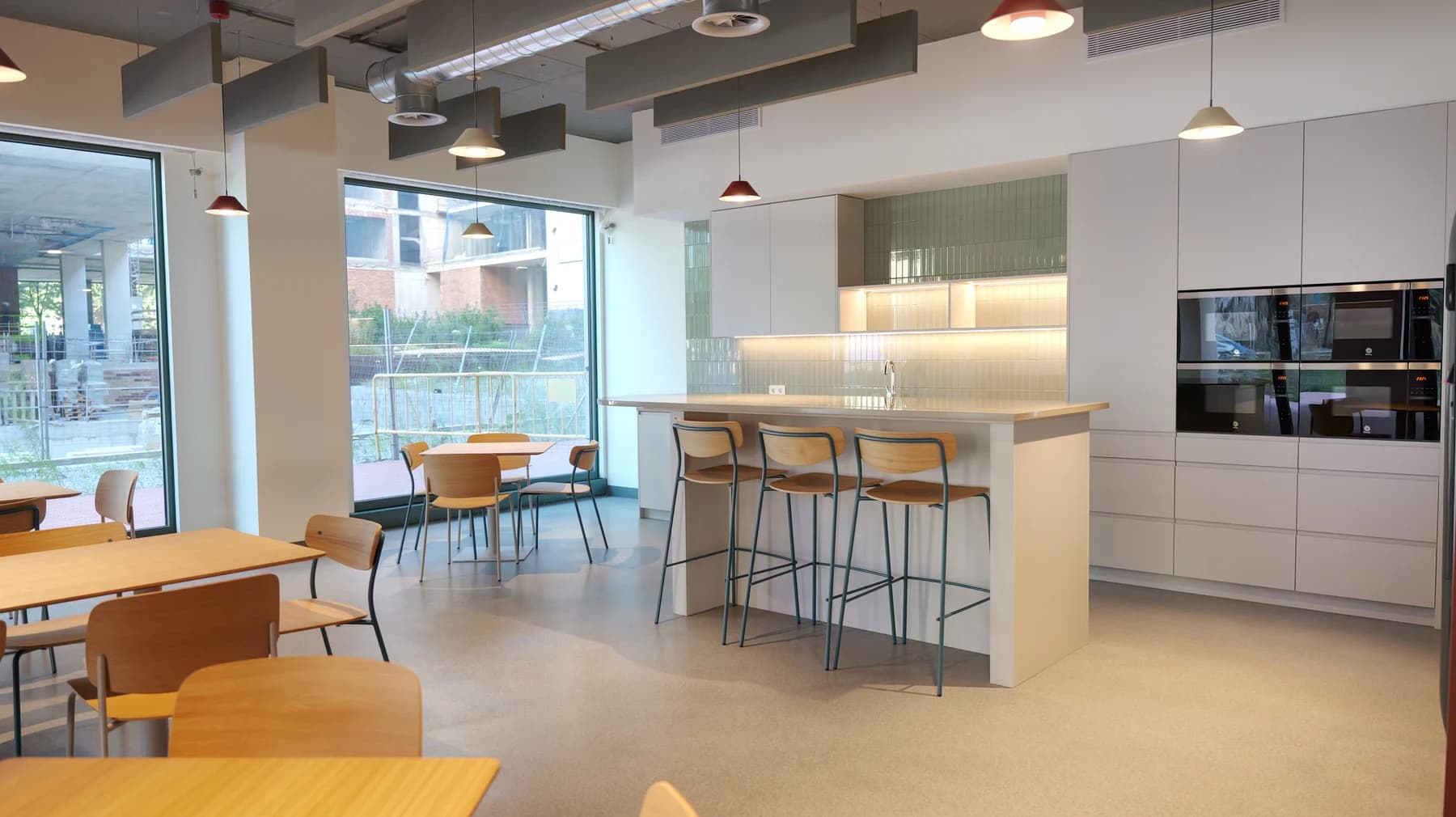 The venue kitchen with a long counter, bar stools and tables beside the windows